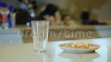 一个面目全非的女人把橙汁倒进杯子里喝。 健康食品和清淡早餐